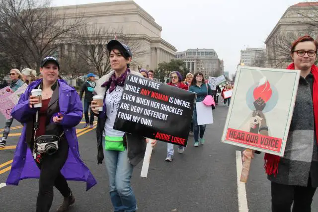 a women holds an audre lorde placard